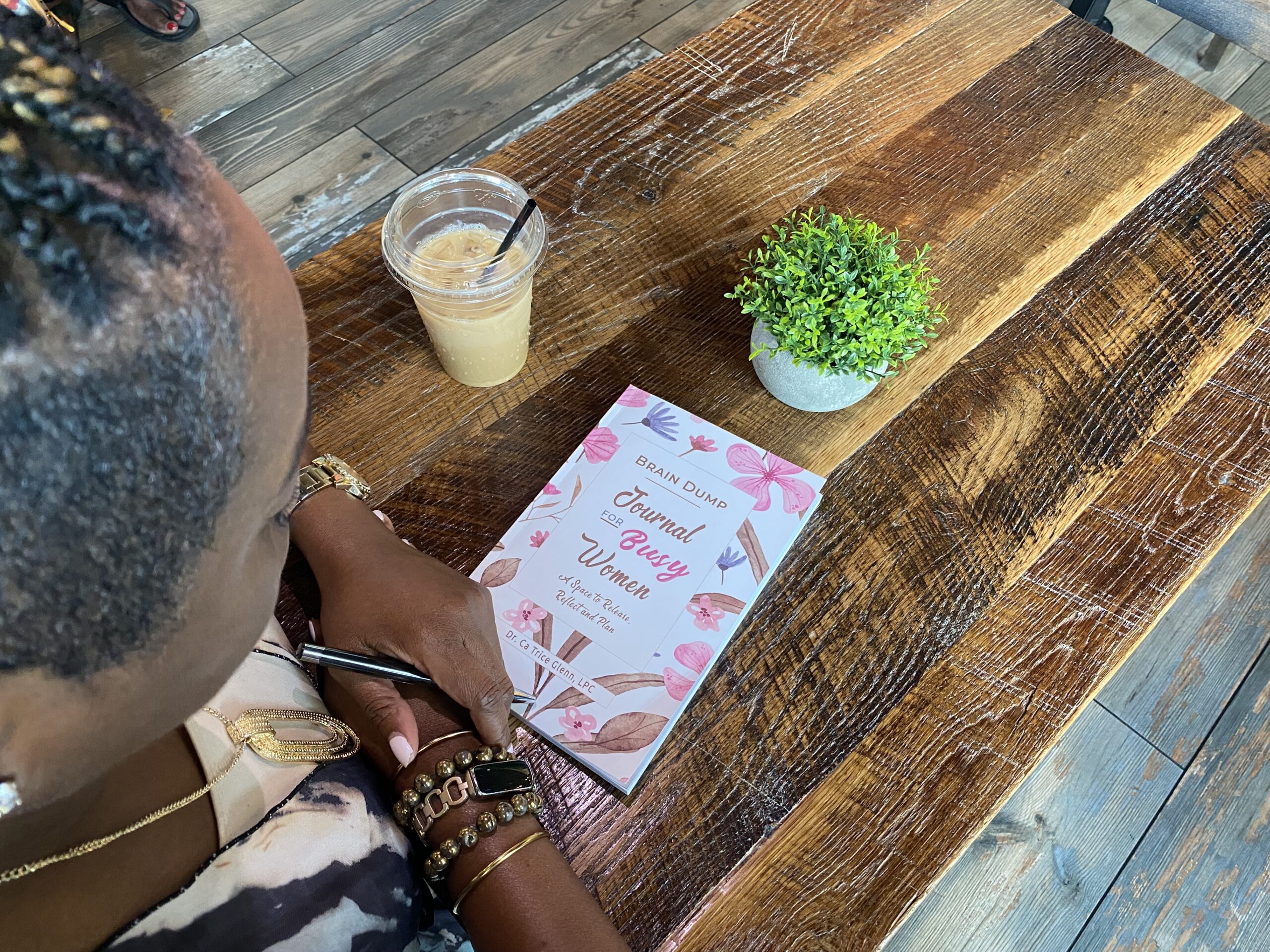 Person reflecting and writing in a Brain Dump for the Busy journal
